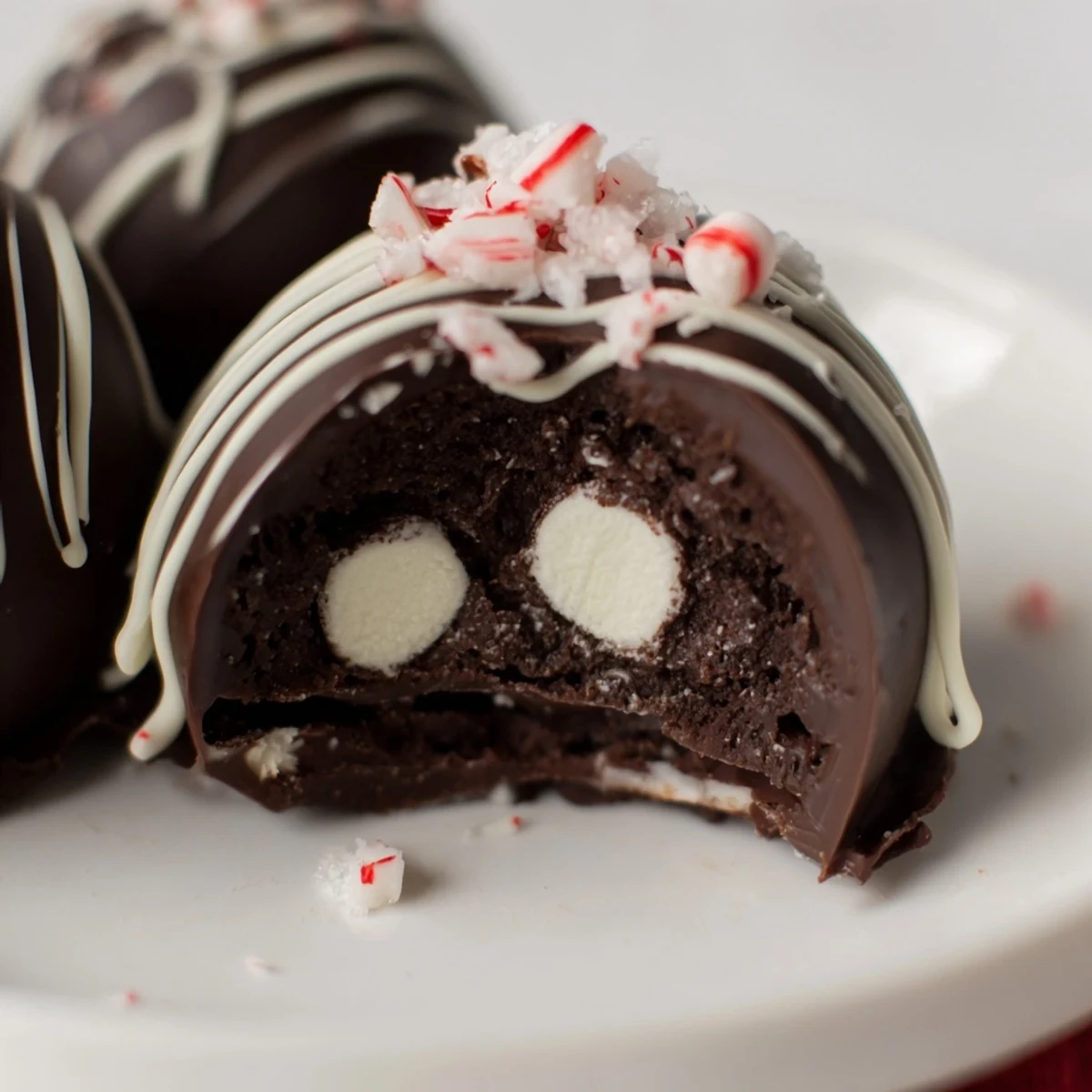 Spoonful of melting chocolate coats silicone molds to create sturdy shells for Peppermint Hot Cocoa Bombs with Marshmallows, ready for a cozy winter drink.