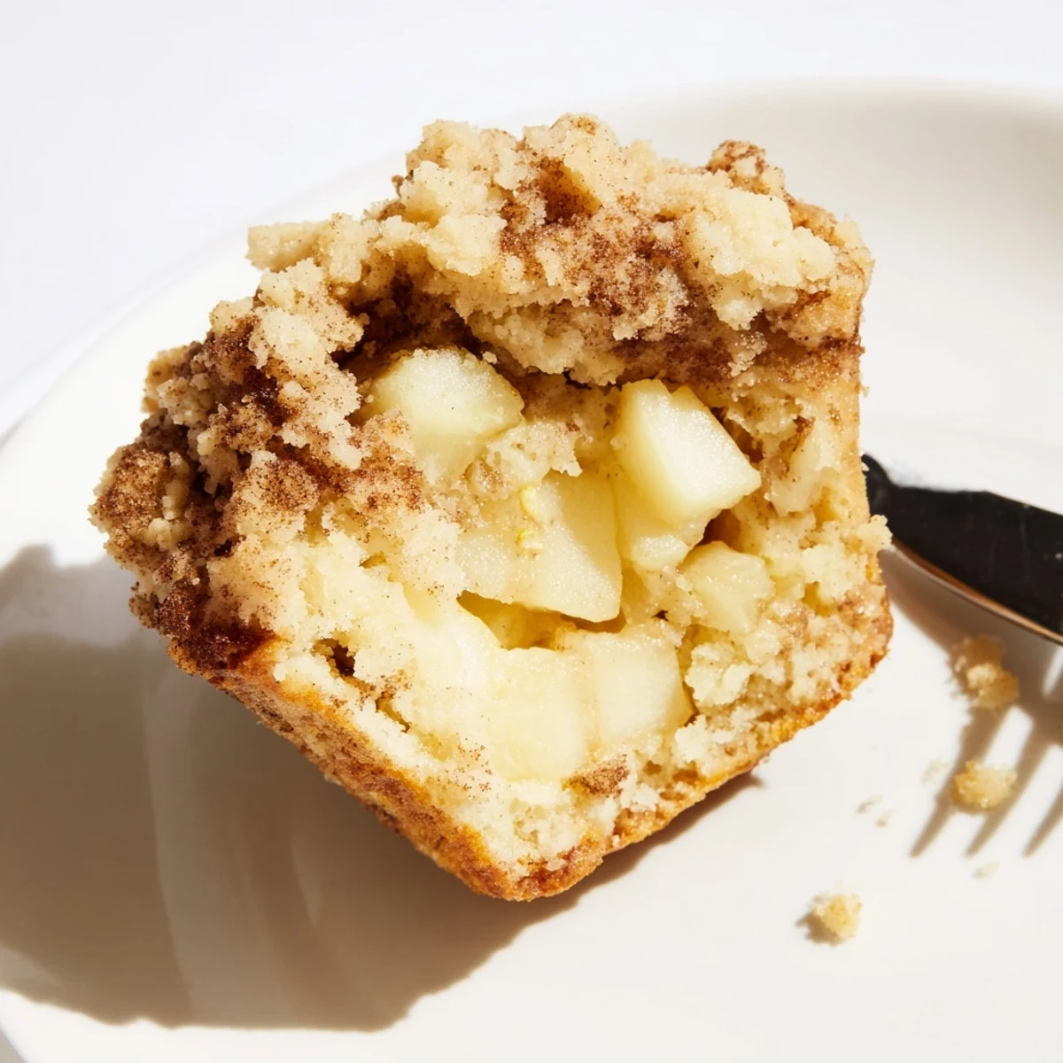 Freshly baked Cinnamon Apple Muffins with Streusel cooling on a wire rack, featuring golden-brown tops and visible apple chunks.