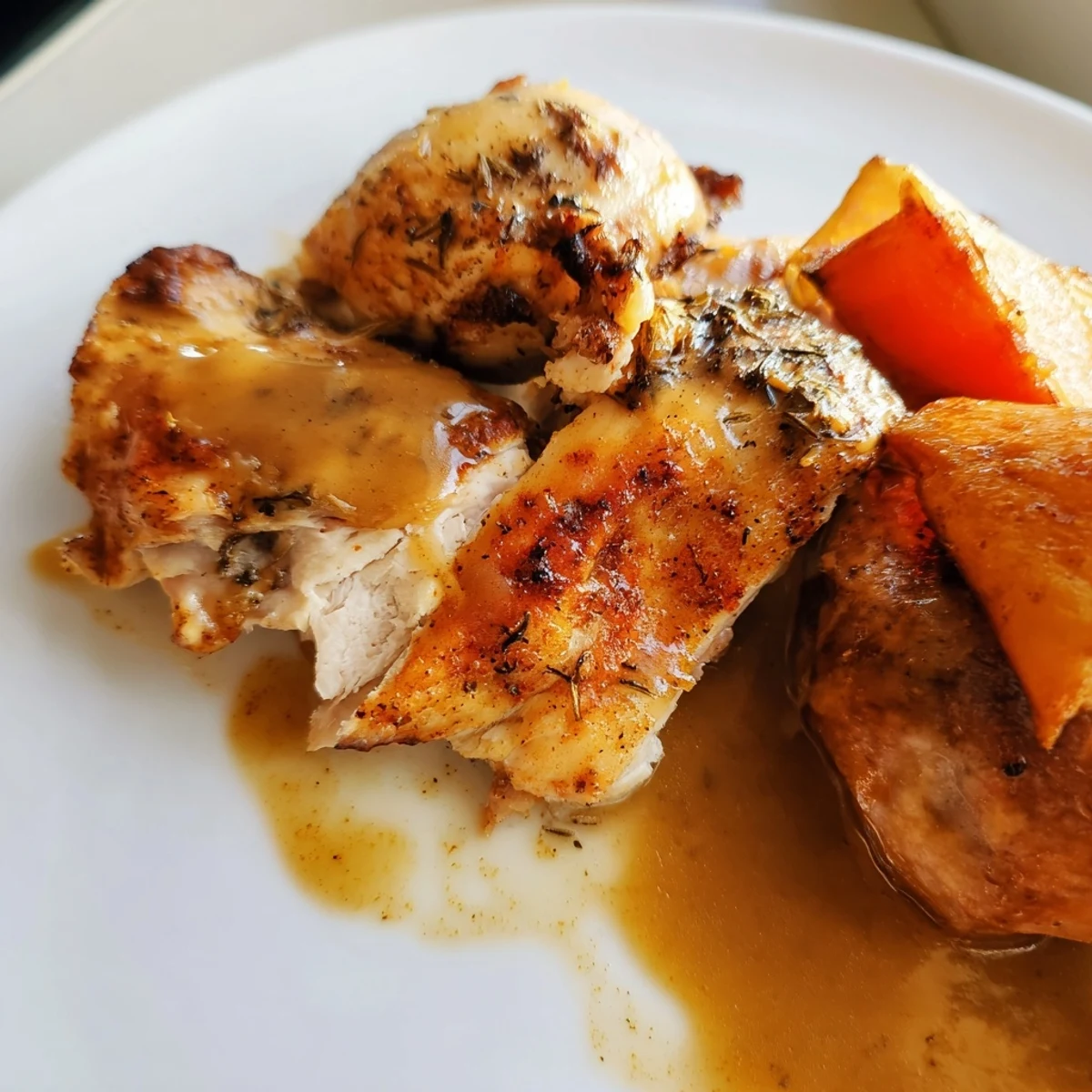 Fresh herbs garnish this hearty Roasted Chicken with Vegetables and Gravy, served warm with rich gravy poured from a silver boat.