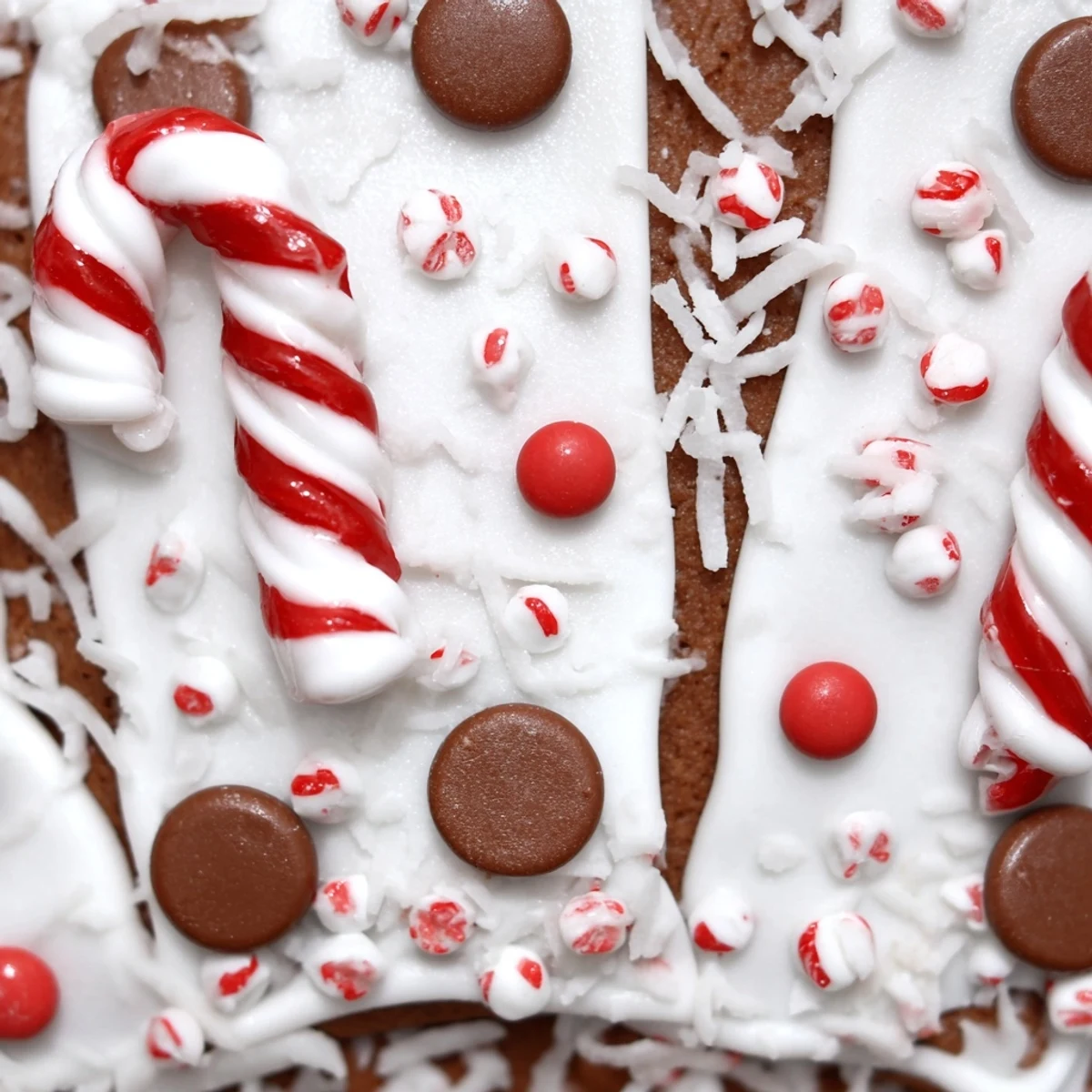 Assembled gingerbread house kit with piped white royal icing seams and colorful candy decorations like gumdrops and candy canes.