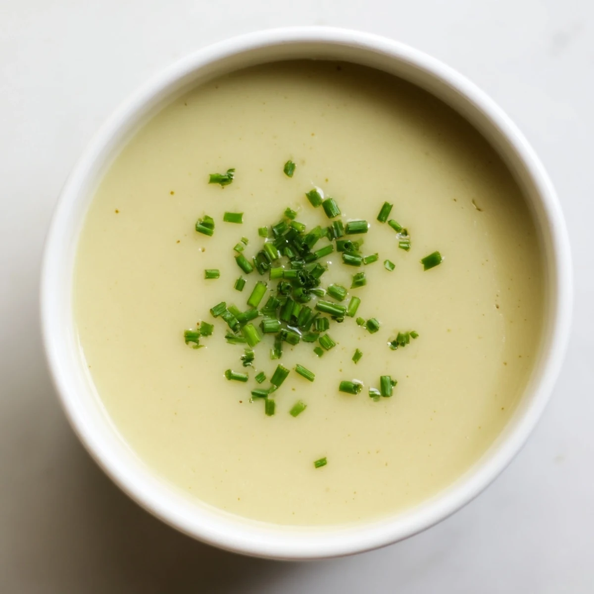 A bowl of Creamy Leek Soup with velvety texture, featuring tender leeks and potatoes, ready to be paired with crusty bread.  