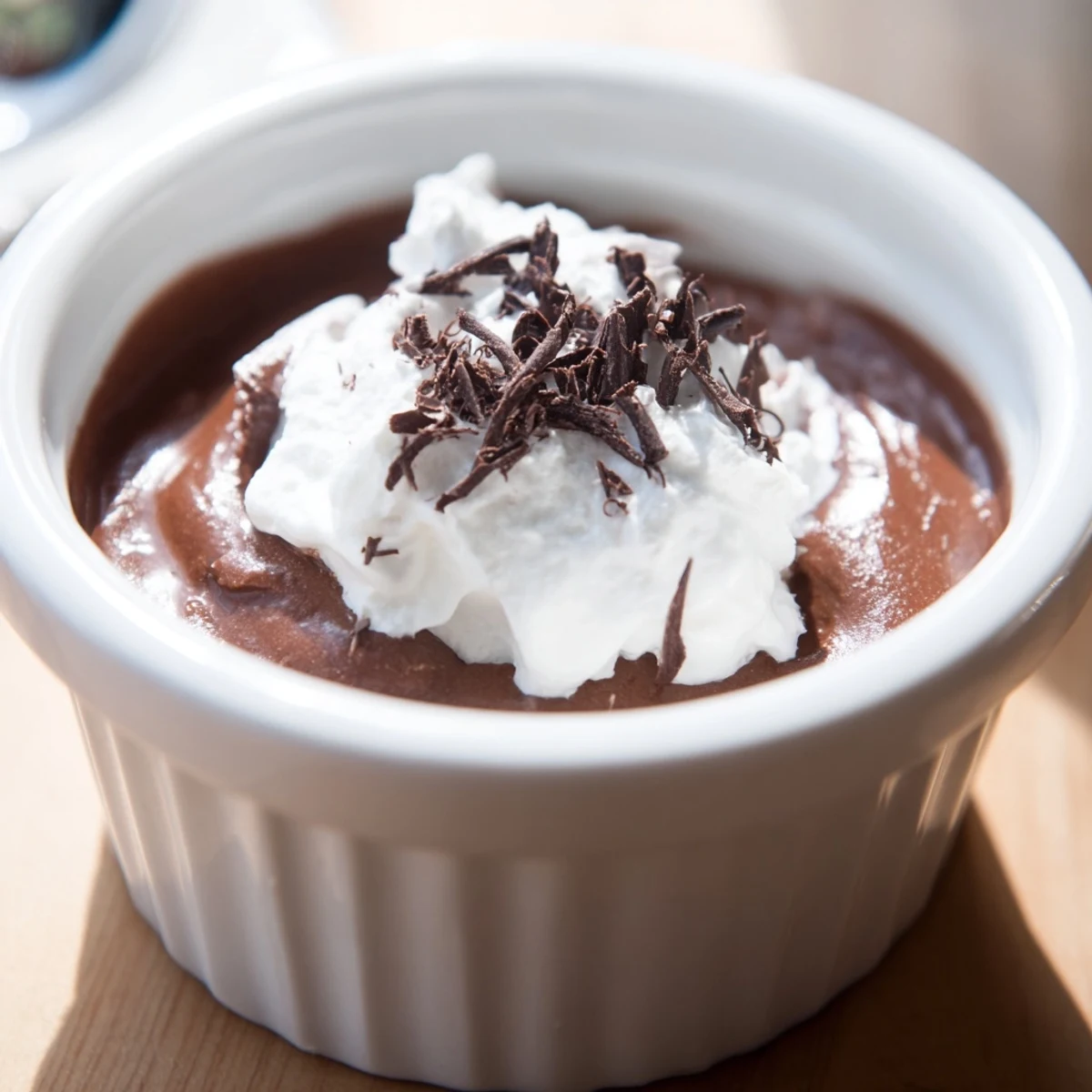 Steaming bowls of rich, creamy chocolate pudding garnished with a dollop of fresh whipped cream.