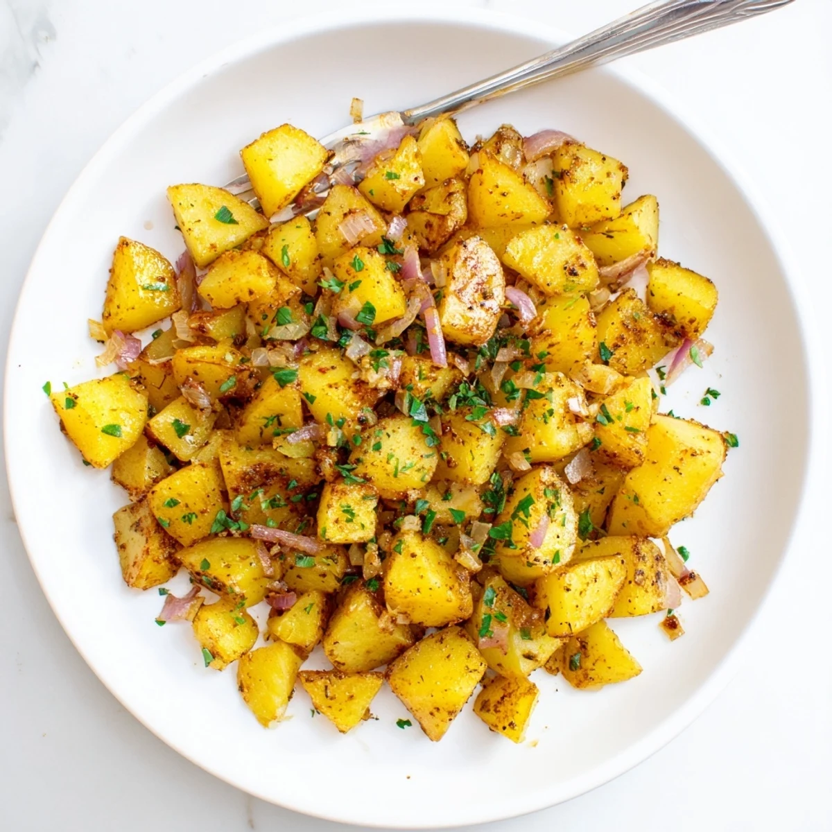 Crispy roasted breakfast potatoes with fresh herbs, golden-brown cubes served warm from the oven.  
