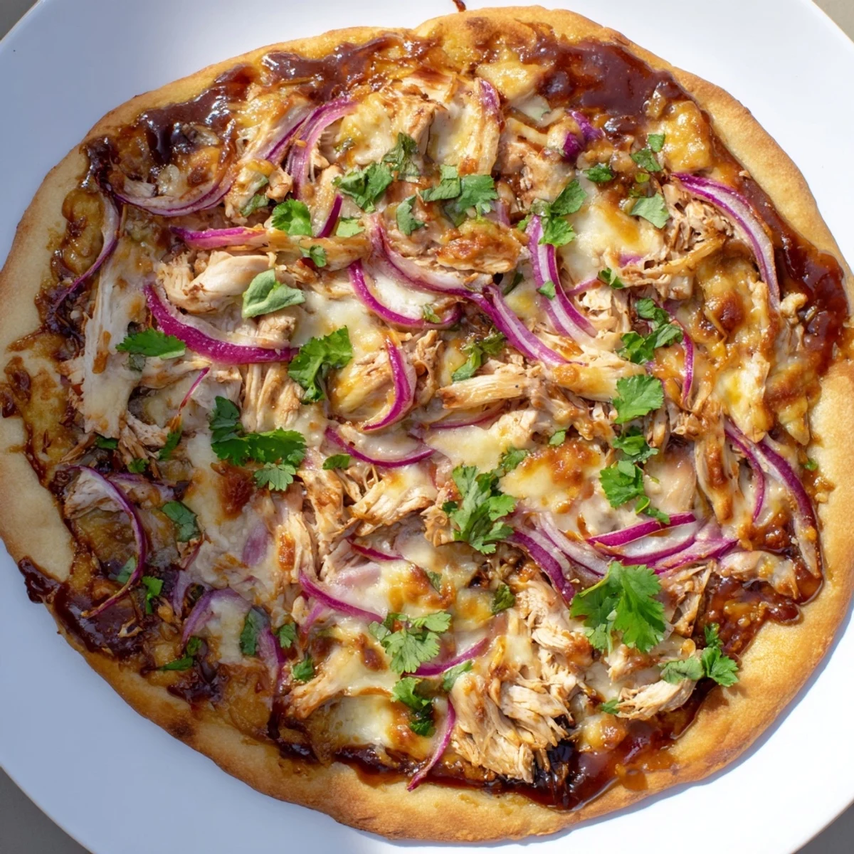 This golden-brown BBQ Chicken Pizza is ready to serve, featuring a generous scattering of fresh green cilantro over savory toppings, making it an ideal centerpiece for a casual American dinner.