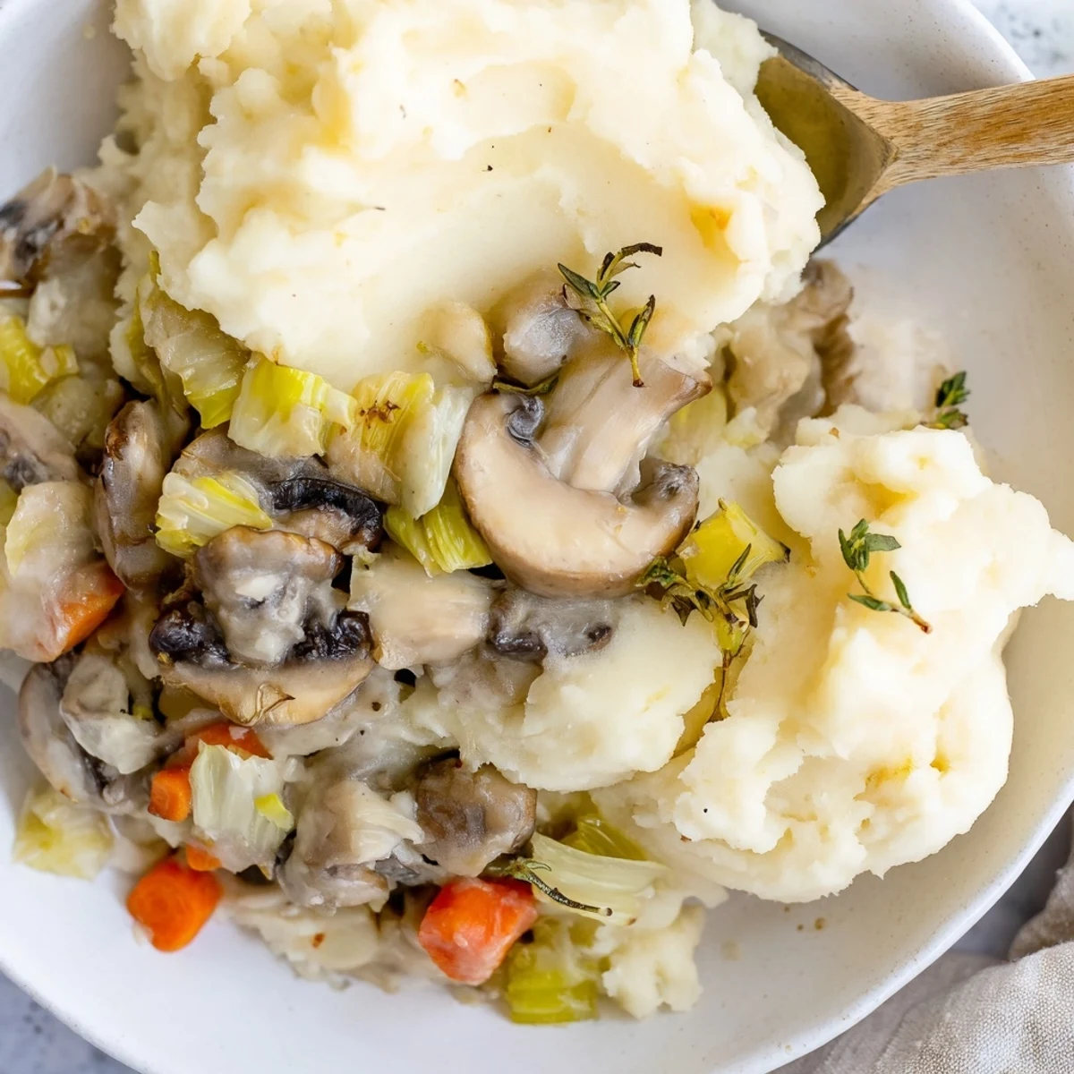 Creamy Mushroom and Leek Shepherds Pie served bubbling from the oven, topped with buttery mashed potatoes and fresh thyme.  