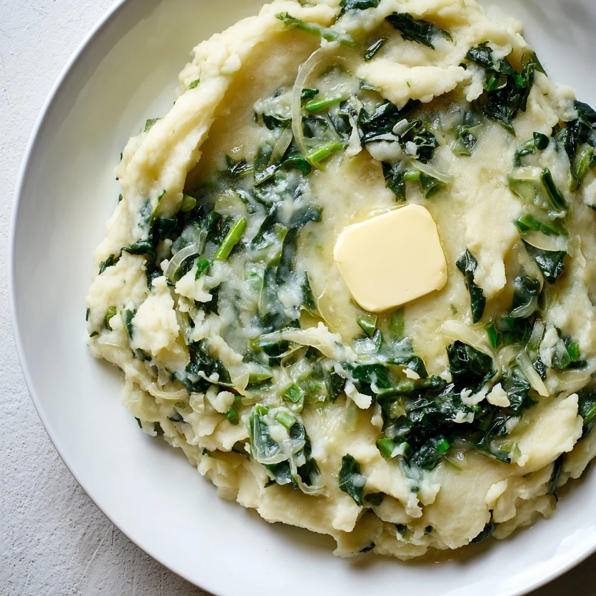 A generous serving of Irish Colcannon with kale and butter, showing green flecks in mashed potatoes.