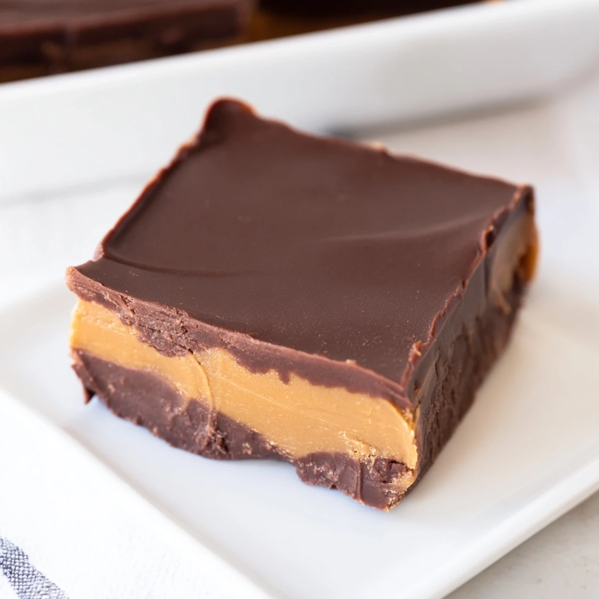 Homemade Chocolate Peanut Butter Fudge Squares cut into neat pieces, showing a swirled texture from the peanut butter and chocolate layers.