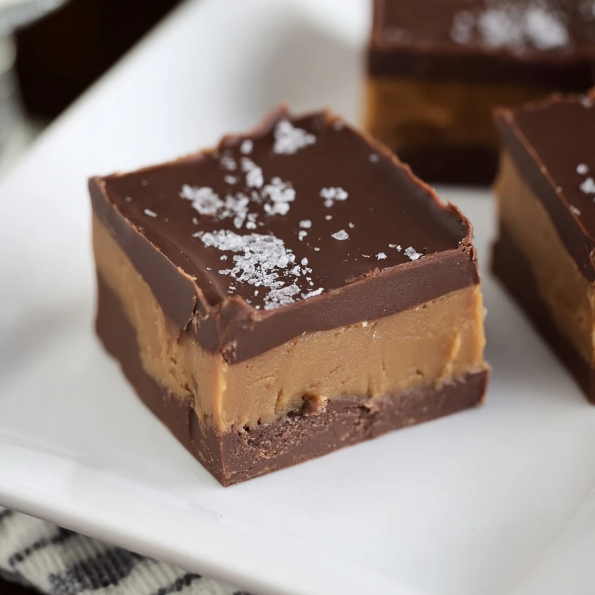 Rich, creamy Chocolate Peanut Butter Fudge Squares with a smooth peanut butter base and decadent chocolate top layer, perfect for a sweet dessert.