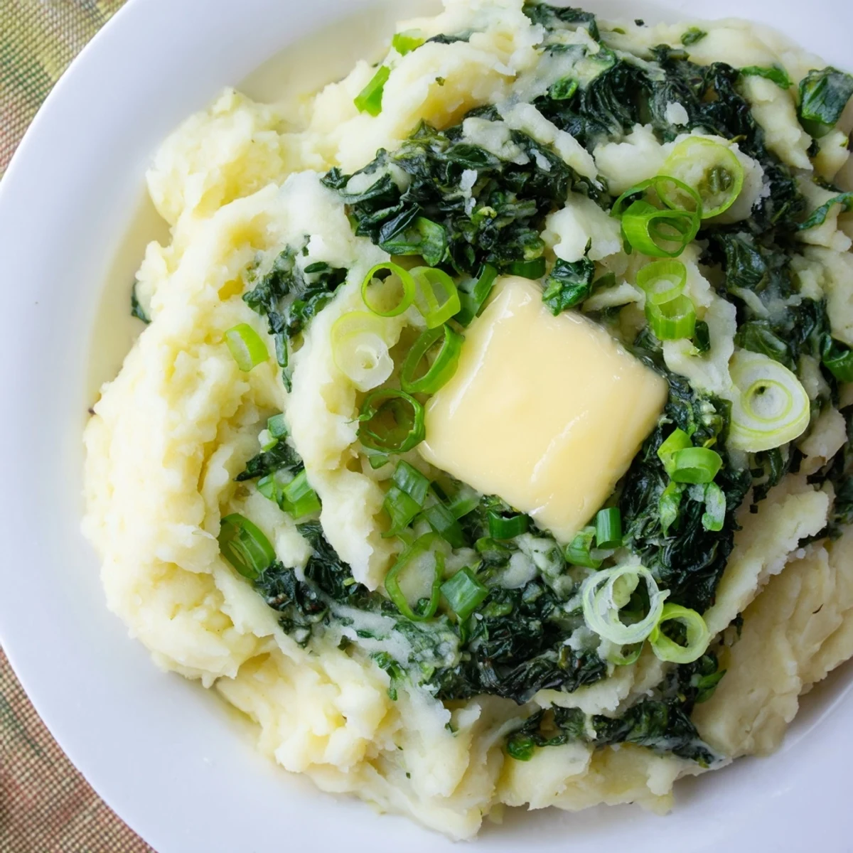 Creamy Irish Colcannon with Kale and Butter served steaming in a rustic bowl beside a golden pat of butter.