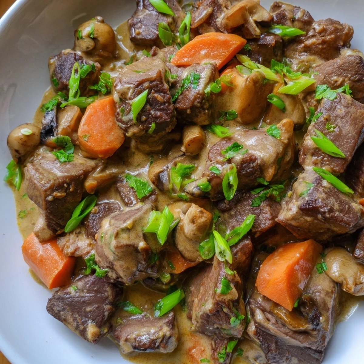Fragrant Lemongrass Coconut Braised Beef with Mushrooms served in a rustic bowl with lime wedges.