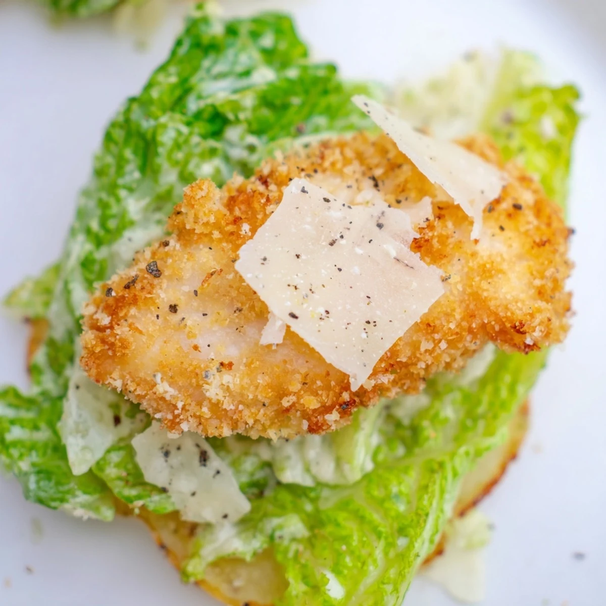 Crispy Chicken Caesar Salad Chips served with lemon wedges on a rustic wooden board for a fun appetizer bite.