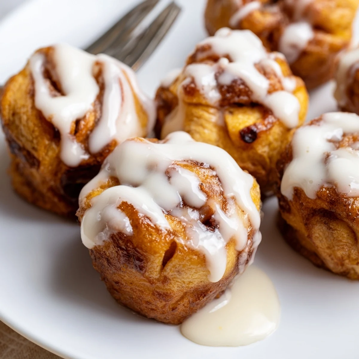 Decadent Cinnamon Roll French Toast Bites with maple syrup and powdered sugar topping.