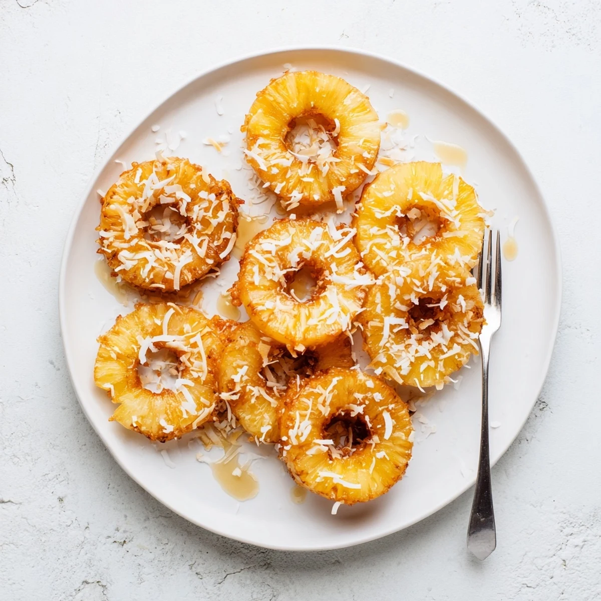Golden, caramelized Fried Pineapple rings sizzling in a skillet with a crispy, golden-brown batter for a sweet tropical dessert.