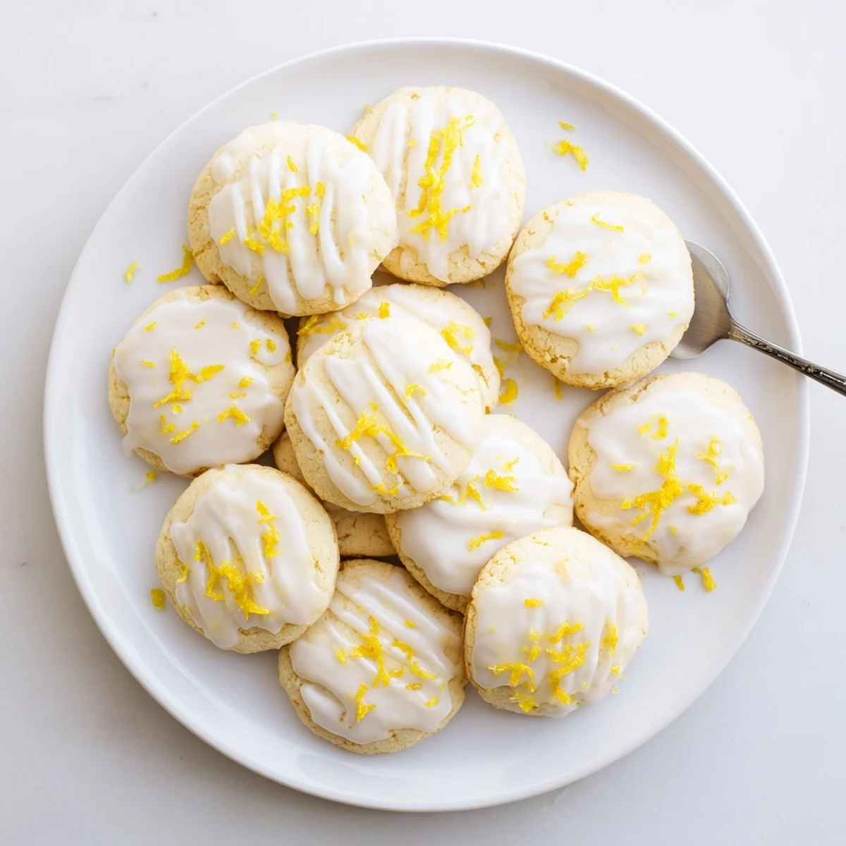 Plate of Limoncello Cookies beside a glass of Limoncello liqueur, perfect for a sunny spring gathering.