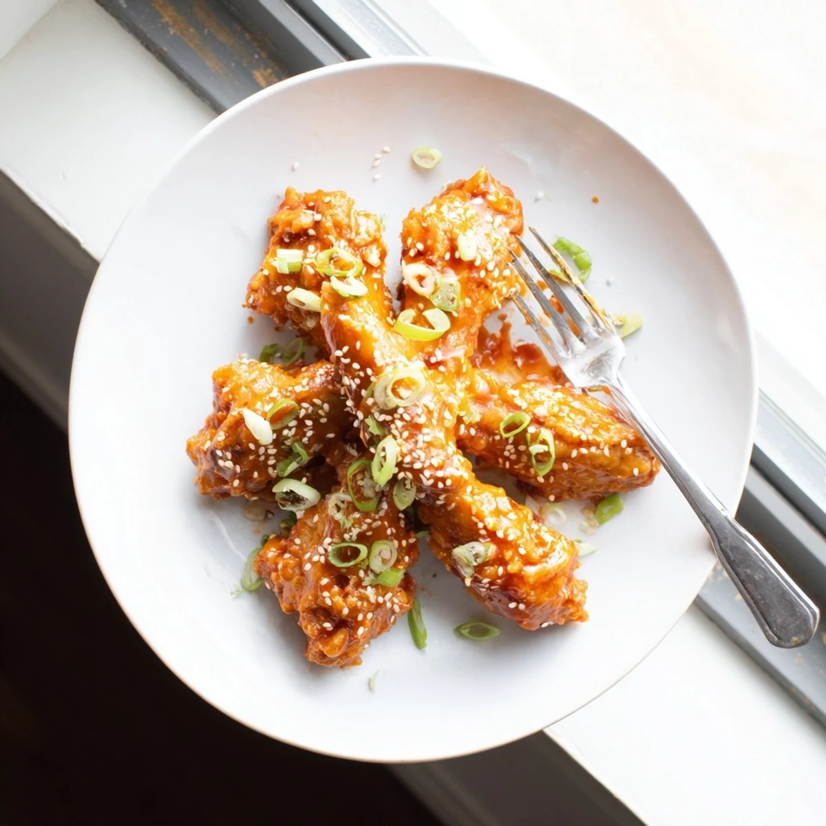 Glossy Sticky Orange Chicken Wings coated in sweet tangy glaze with garlic and ginger for a party snack.