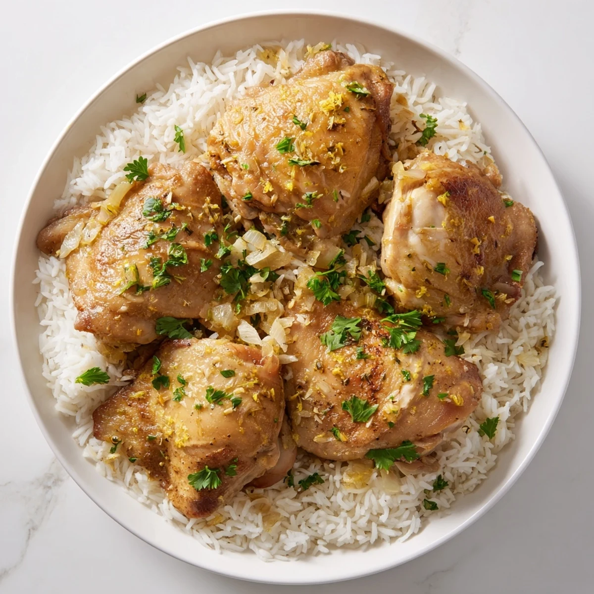 Golden brown chicken thighs with bright lemon and herbs served over steaming fluffy rice