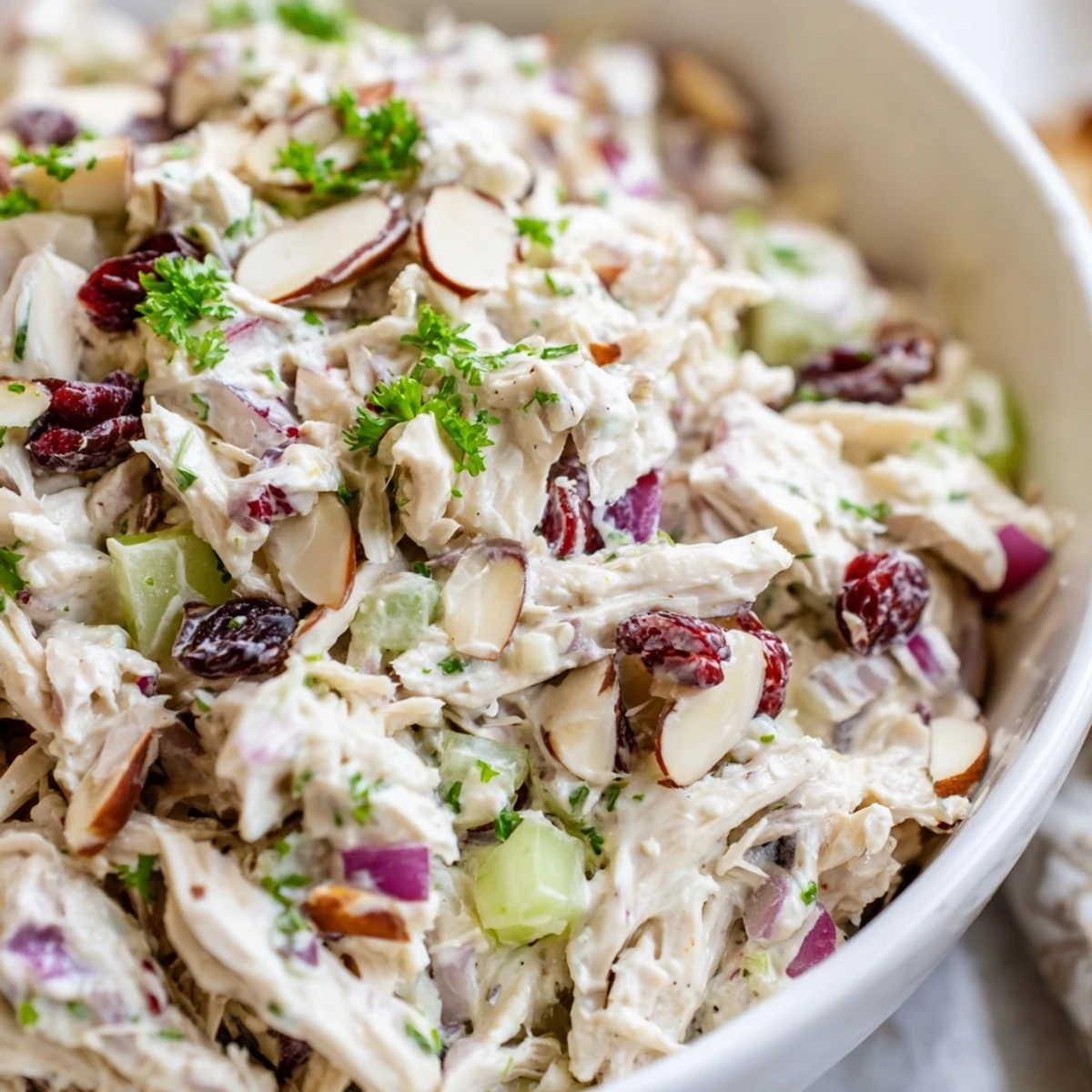 Creamy Greek yogurt rotisserie chicken salad with crisp red peppers and fresh parsley served on leafy greens