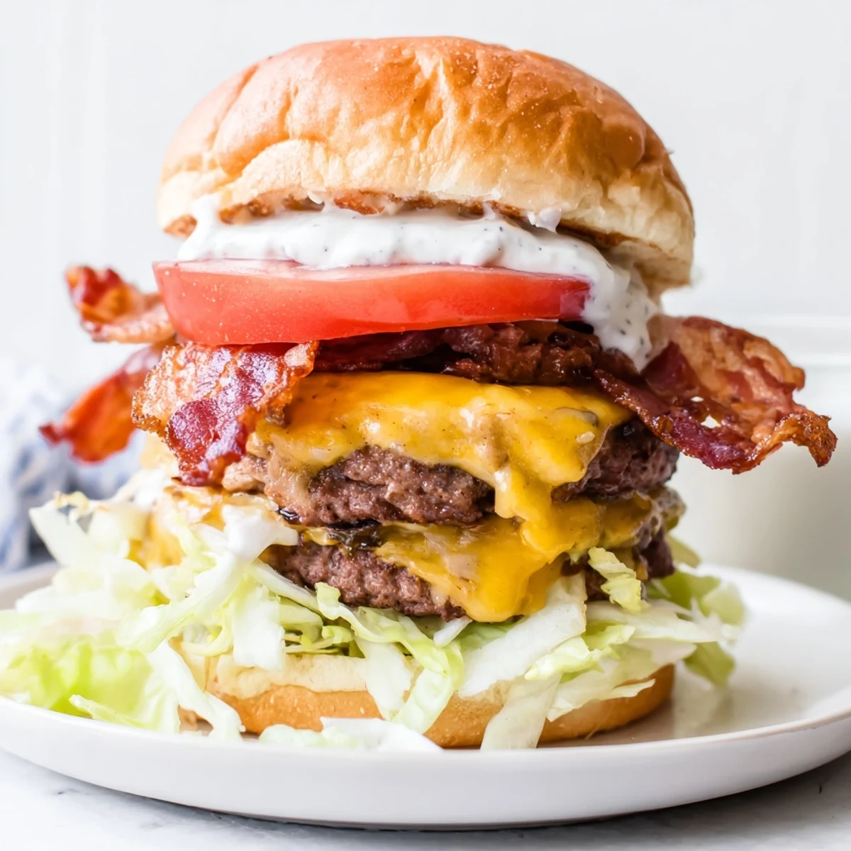 Mouthwatering Crack Burgers featuring cheese-topped beef patties layered with bacon, fresh lettuce, tomato, and pickles