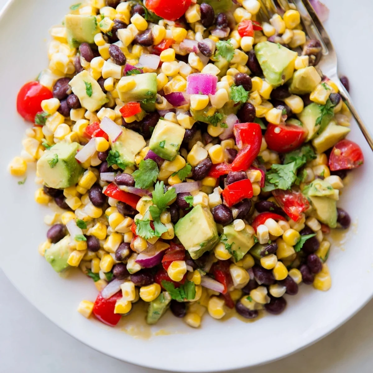 Colorful corn and black bean salad with avocado and lime dressing