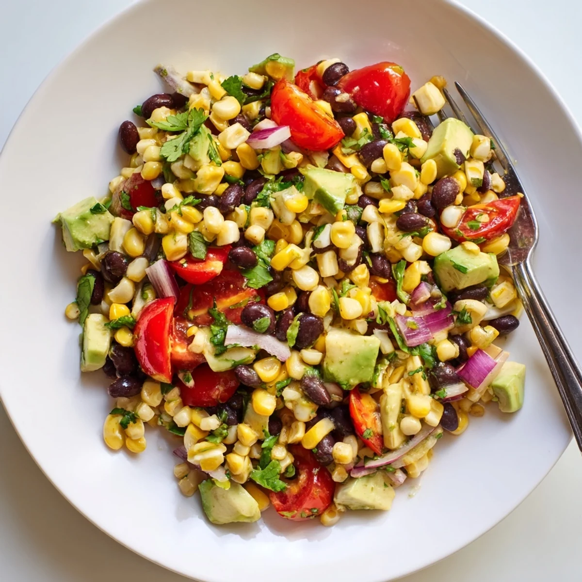 Vibrant Tex-Mex corn and black bean salad in a white serving bowl