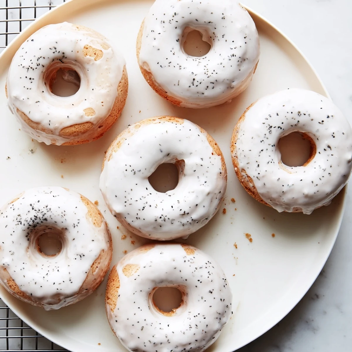 Golden brown Earl Grey mochi donuts dipped in sweet white glaze on wire rack