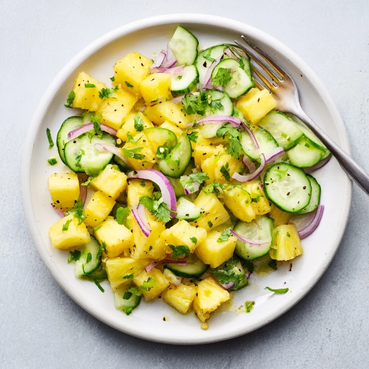 Close-up of tropical pineapple cucumber salad with green cilantro and honey lime glaze
