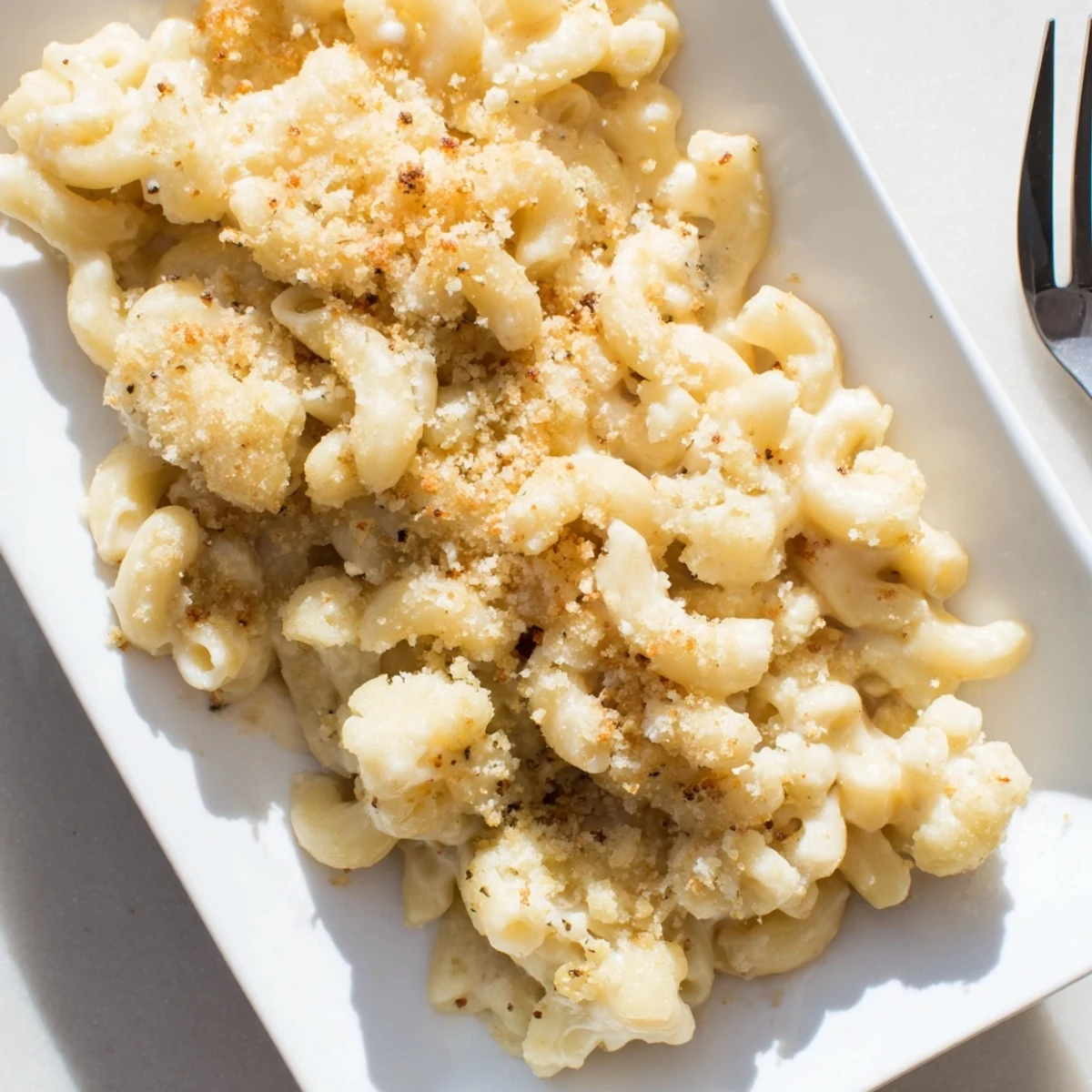 Baked cauliflower mac n cheese casserole topped with crispy breadcrumbs and melted cheese blend