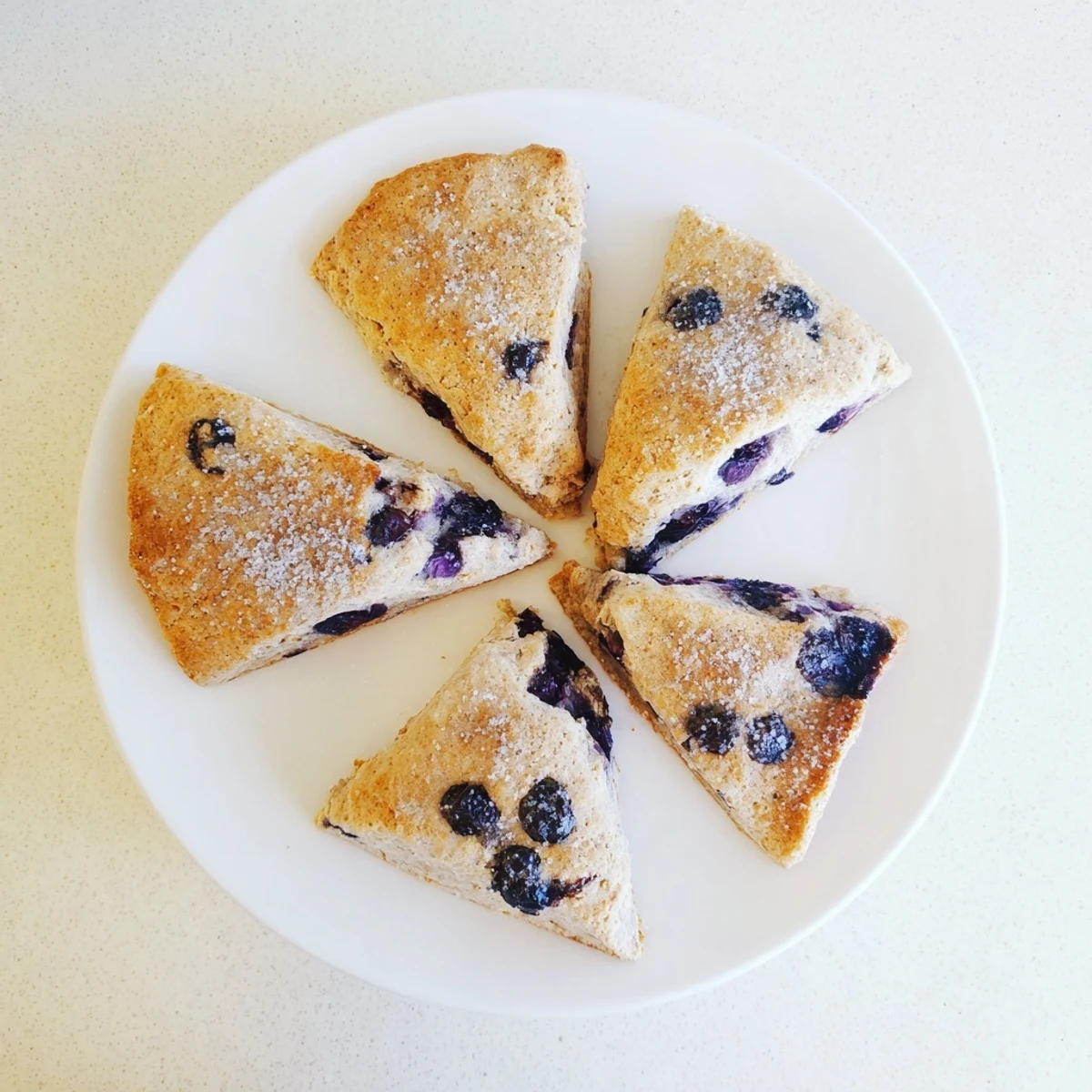 Tender baked blueberry scones sprinkled with aromatic Vietnamese cinnamon and coarse sparkling sugar