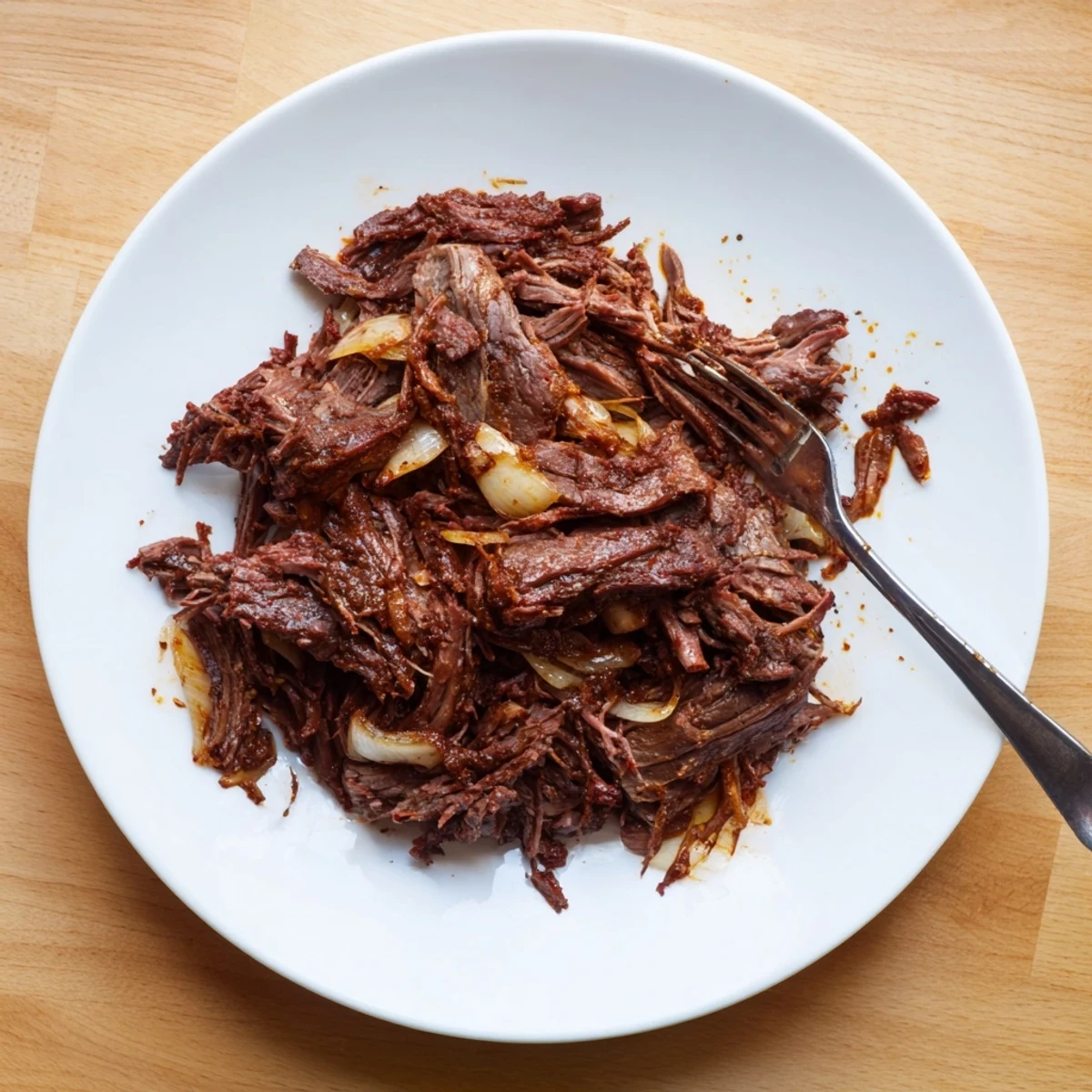 Crock Pot shredded beef with fork-tender pieces coated in rich, spiced juices