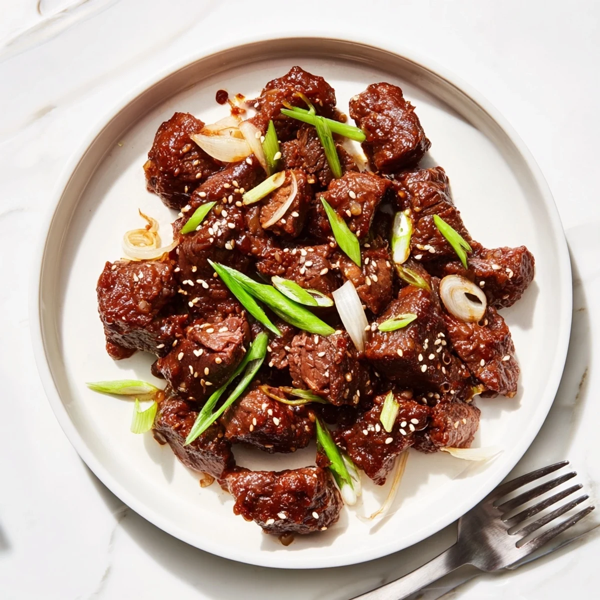 Tender slow cooker Korean beef shredded in a rich glossy brown sauce with sesame seed garnish