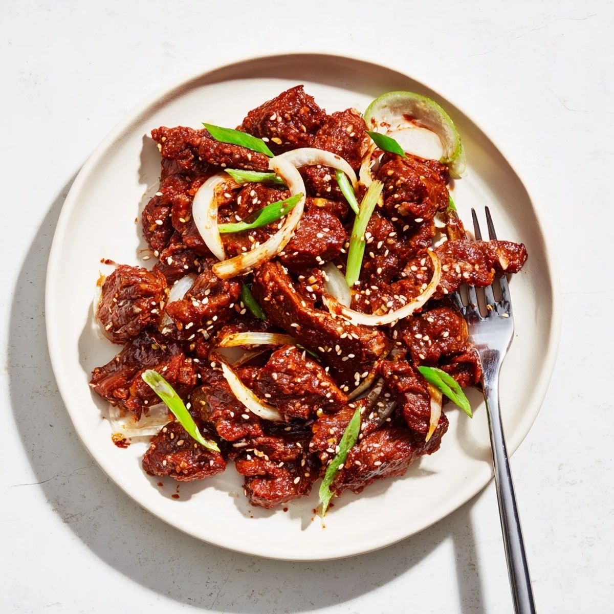 Melt-in-your-mouth slow cooker Korean beef coated in sweet and spicy sauce with toasted sesame topping