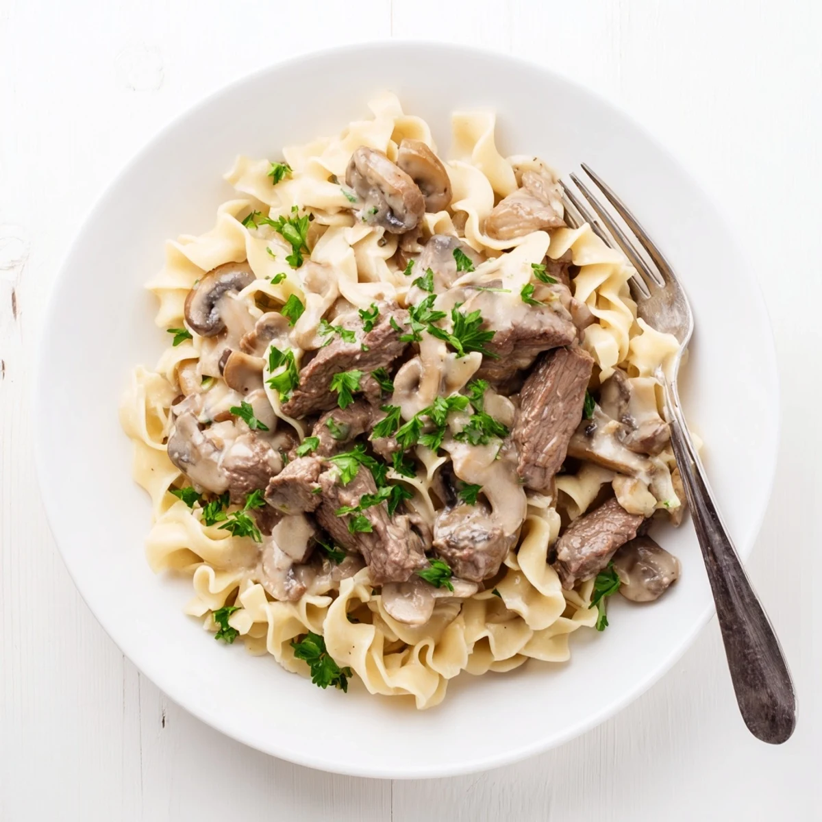Creamy beef stroganoff with tender beef strips and mushrooms served over egg noodles