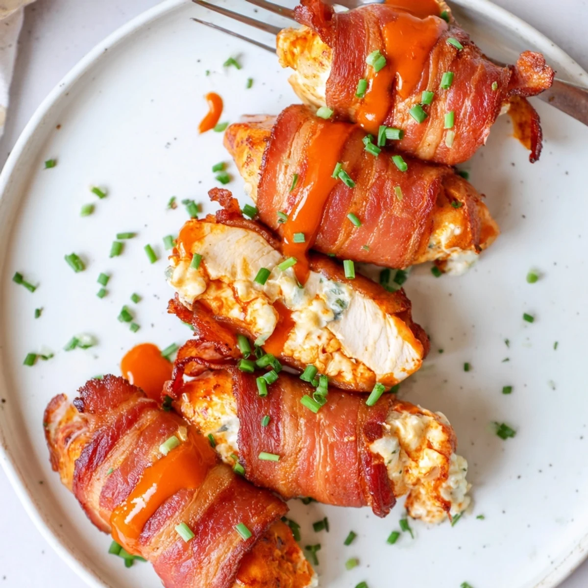 Crispy bacon-wrapped Buffalo Chicken Bombs oozing with creamy cheese and spicy buffalo sauce