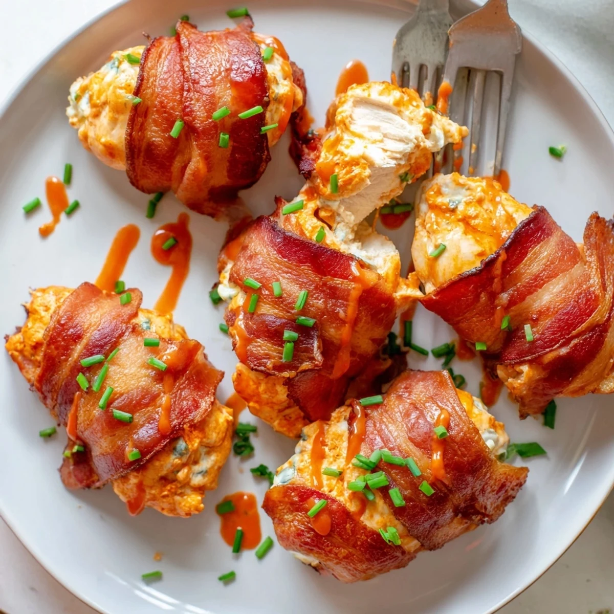 Juicy stuffed Buffalo Chicken Bombs drizzled with extra sauce and garnished with fresh chives