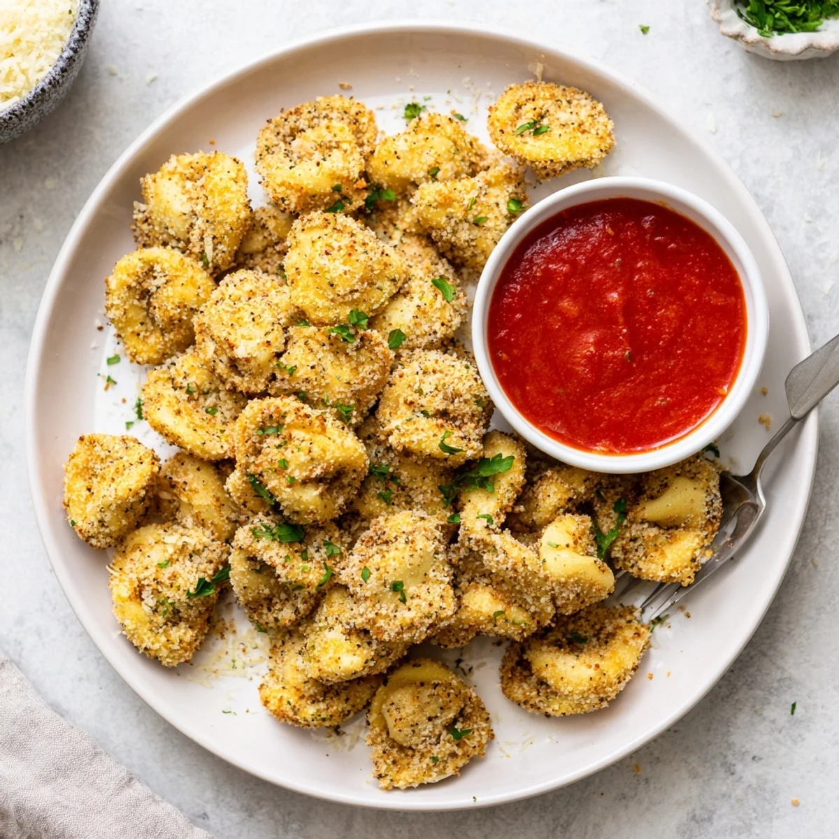 Italian-style air fryer tortellini served with warm marinara and sprinkled fresh herbs