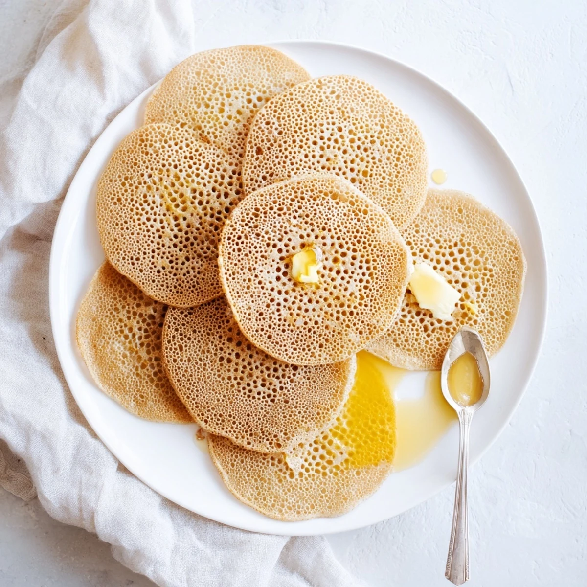 Light and airy baghrir pancakes topped with honey butter, perfect for Moroccan breakfast