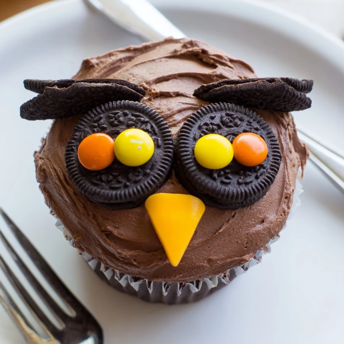 Cute Oreo Owl Cupcakes with chocolate frosting eyes on a rustic serving board