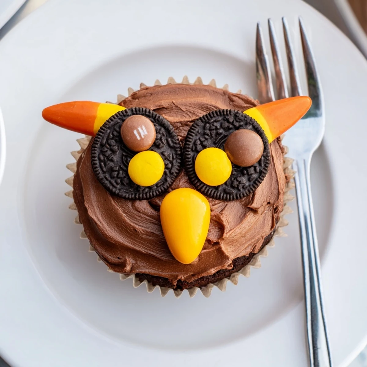 Frosted Oreo Owl Cupcakes topped with cookie eyes and candy beaks displayed beautifully