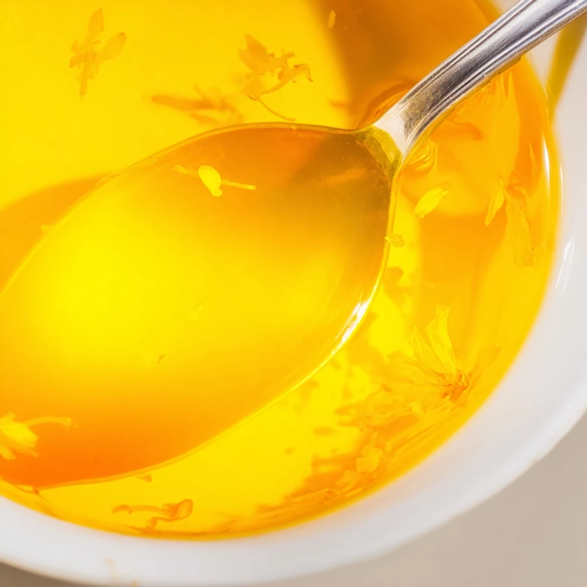 A dollop of homemade fresh dandelion jelly beside soft scones and cheese