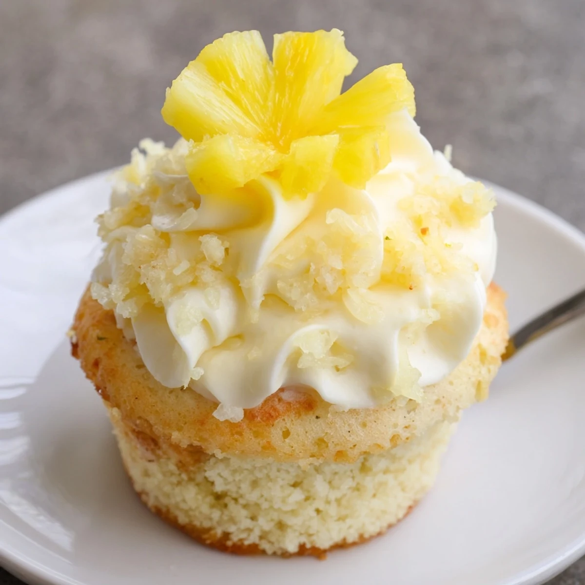 Dole Whip Cupcakes Recipe: fluffy pineapple cupcakes topped with creamy yellow frosting