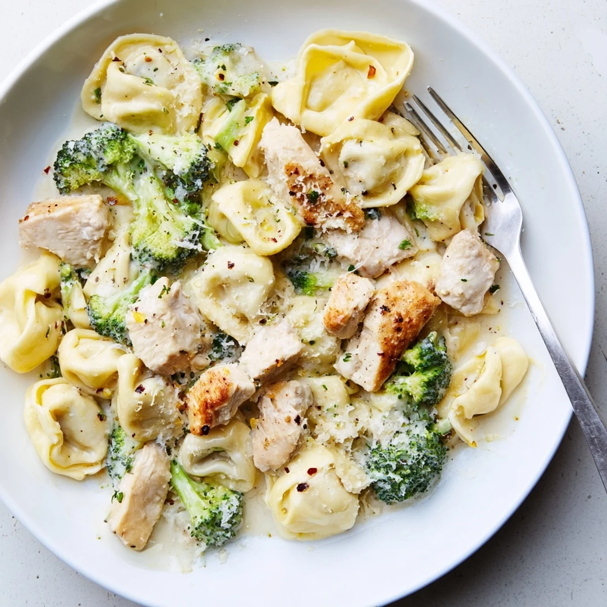 Creamy Garlic Parmesan Tortellini Chicken Broccoli Recipe plated steaming, silky sauce, golden chicken