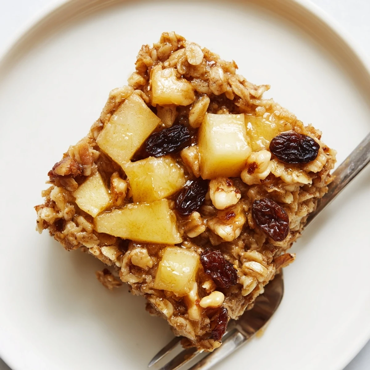 Warm, sliced Delicious Apple Cinnamon Oatmeal Bake Recipe For Mornings drizzled with maple syrup