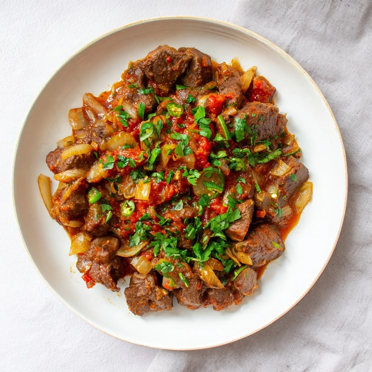 Golden brown goat meat simmered with aromatic spices in a glossy wet fry sauce perfect for family dinner.