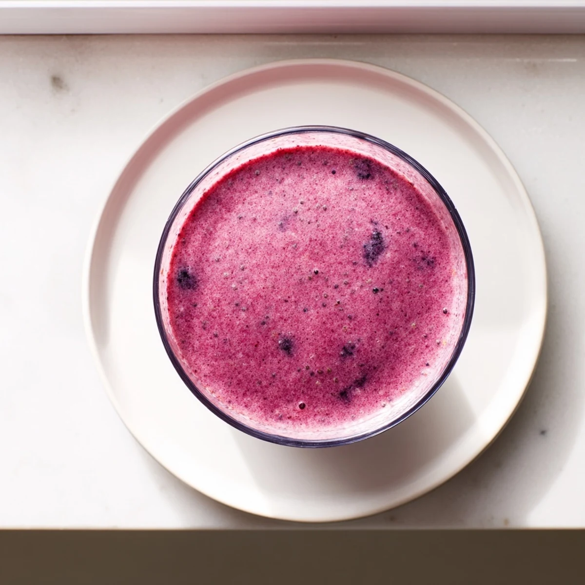 Creamy chia seed smoothie blended with mixed berries and banana, garnished with fresh fruit