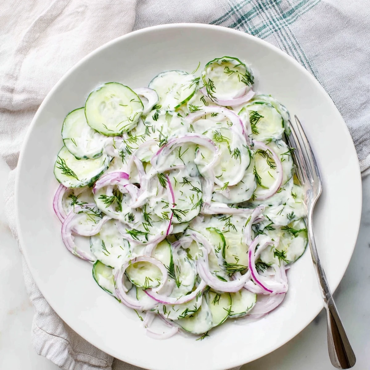 Fresh cucumber dill salad with thinly sliced vegetables in a creamy tangy dressing