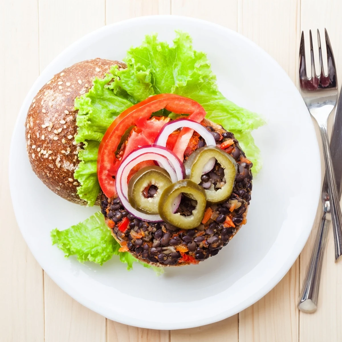 Golden veggie burgers stacked on toasted buns with fresh lettuce, tomato, and creamy sauce
