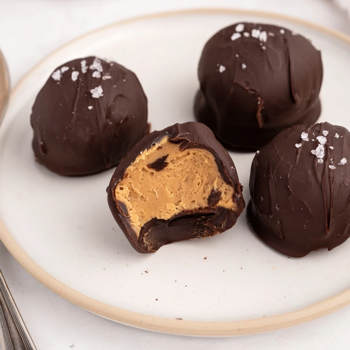 Frozen Peanut Butter Greek Yogurt Bites dipped in dark chocolate, sprinkled with sea salt