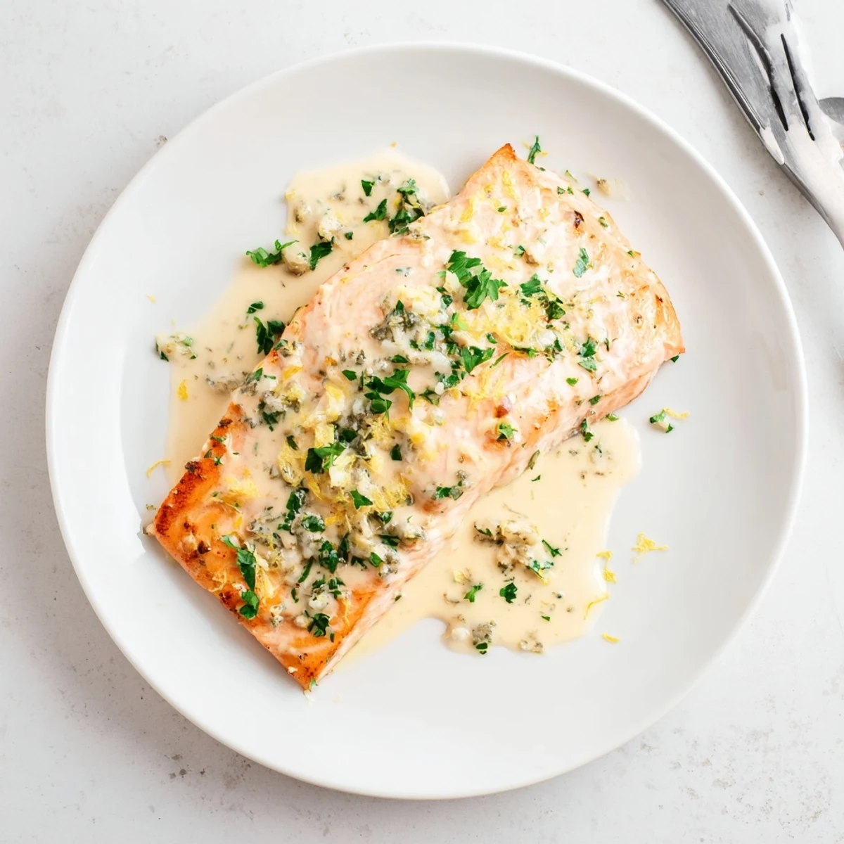 Tender salmon with lemon cream sauce topped with fresh parsley and served with asparagus