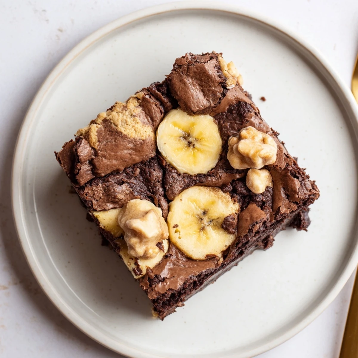 Chilled Banana Pudding Brownies sliced into squares, topped with fresh banana