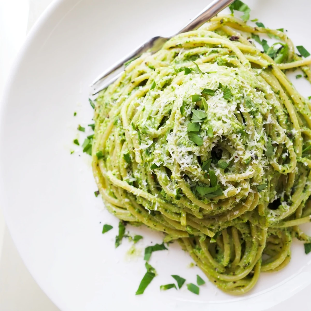 Lush green goddess pasta sauce topped with shaved Parmesan and scattered herb garnish